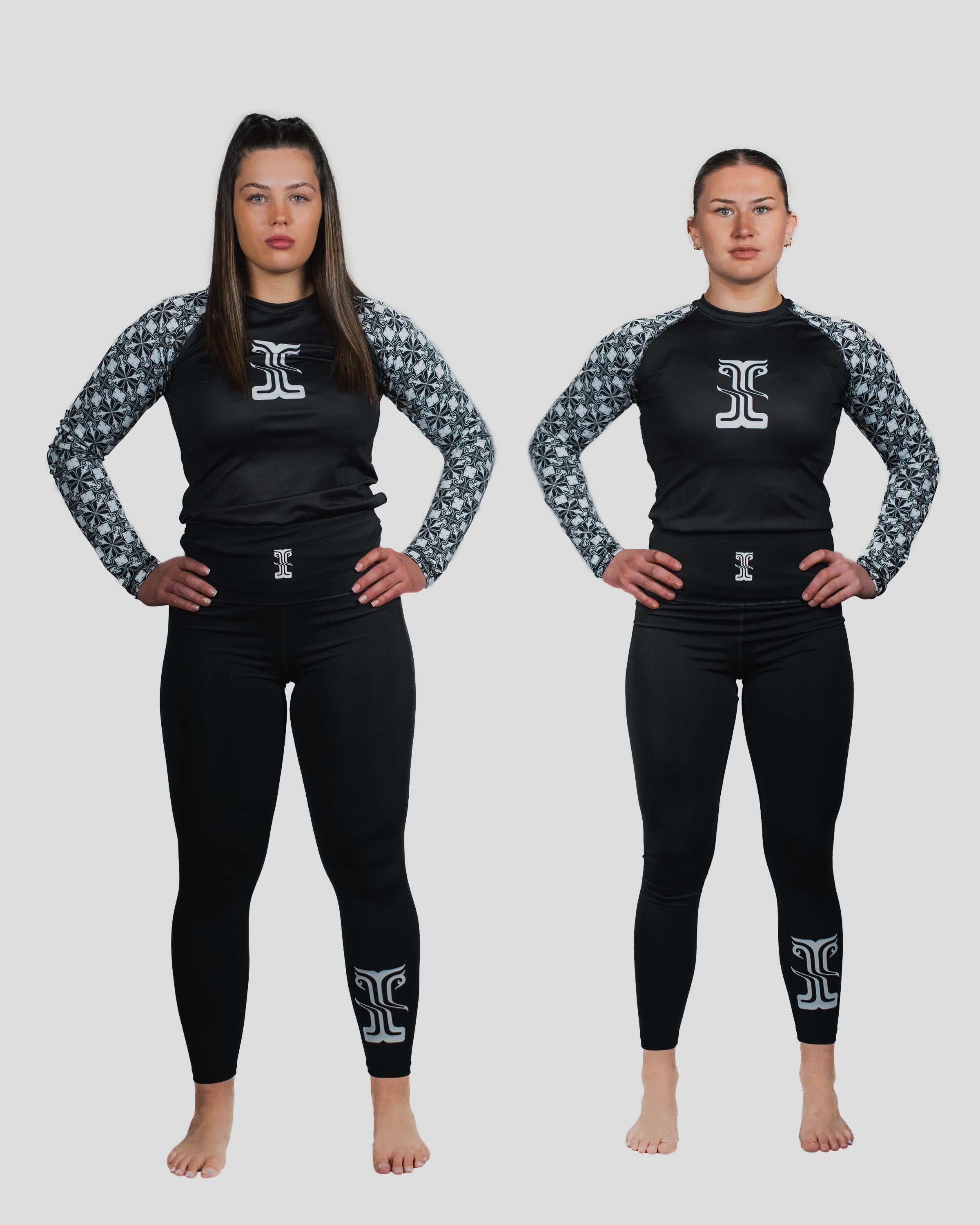 Two female athletes standing side by side in the Gorgo Long Sleeve Rash Guard and matching spats, displaying the fitted design and signature pattern