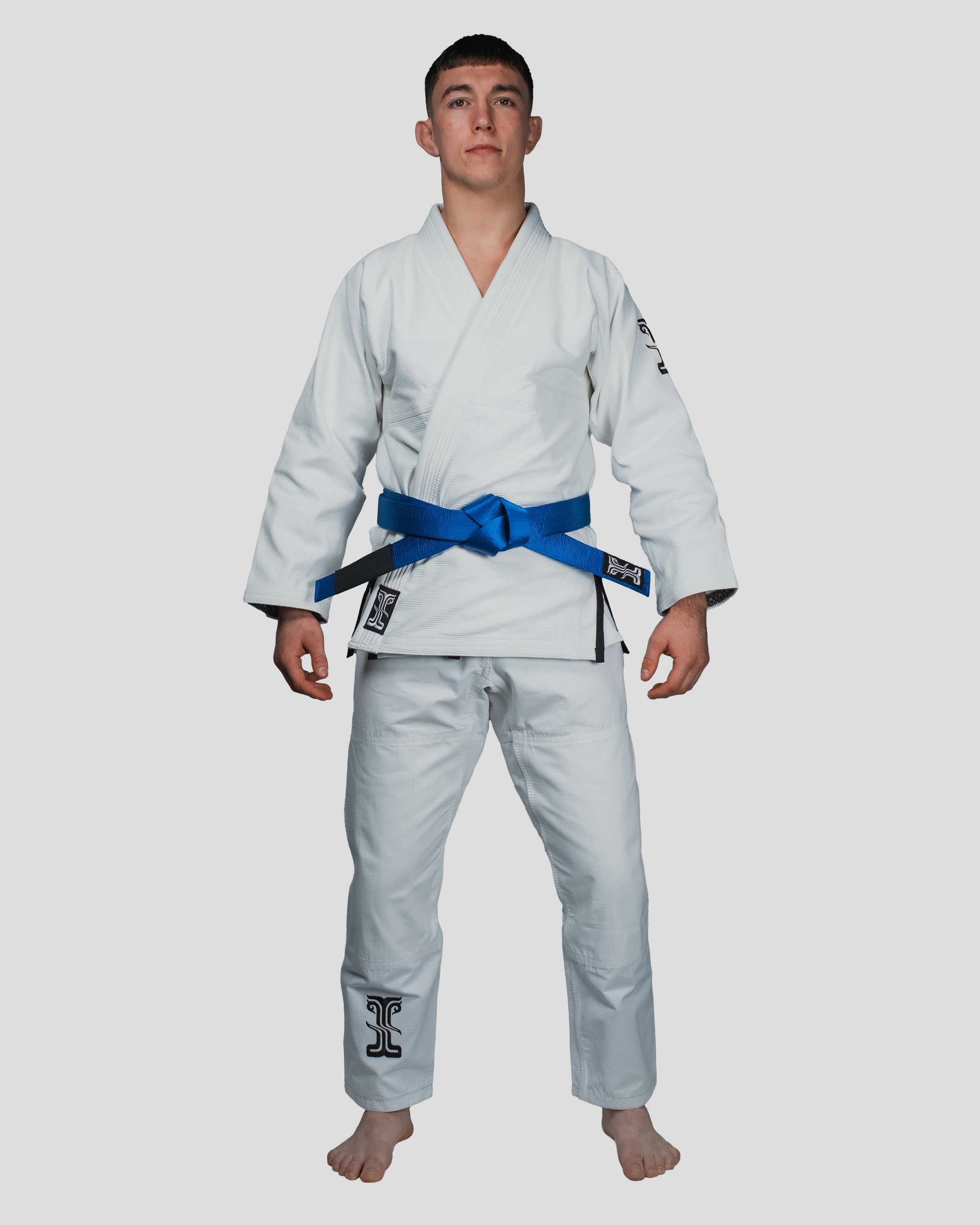 Front view of the Guile Men’s Jiu Jitsu Gi in white, showcasing premium fabric and Kosmos branding