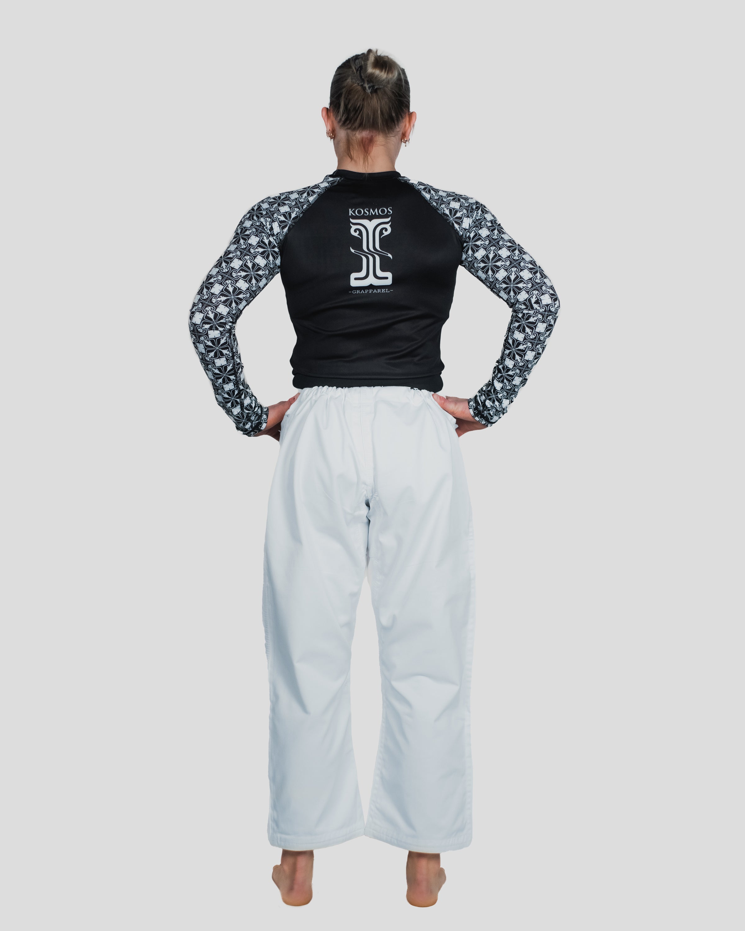Back view of the Persist Long Sleeve Guard on a female athlete, highlighting the Kosmos branding and flexibility of the design