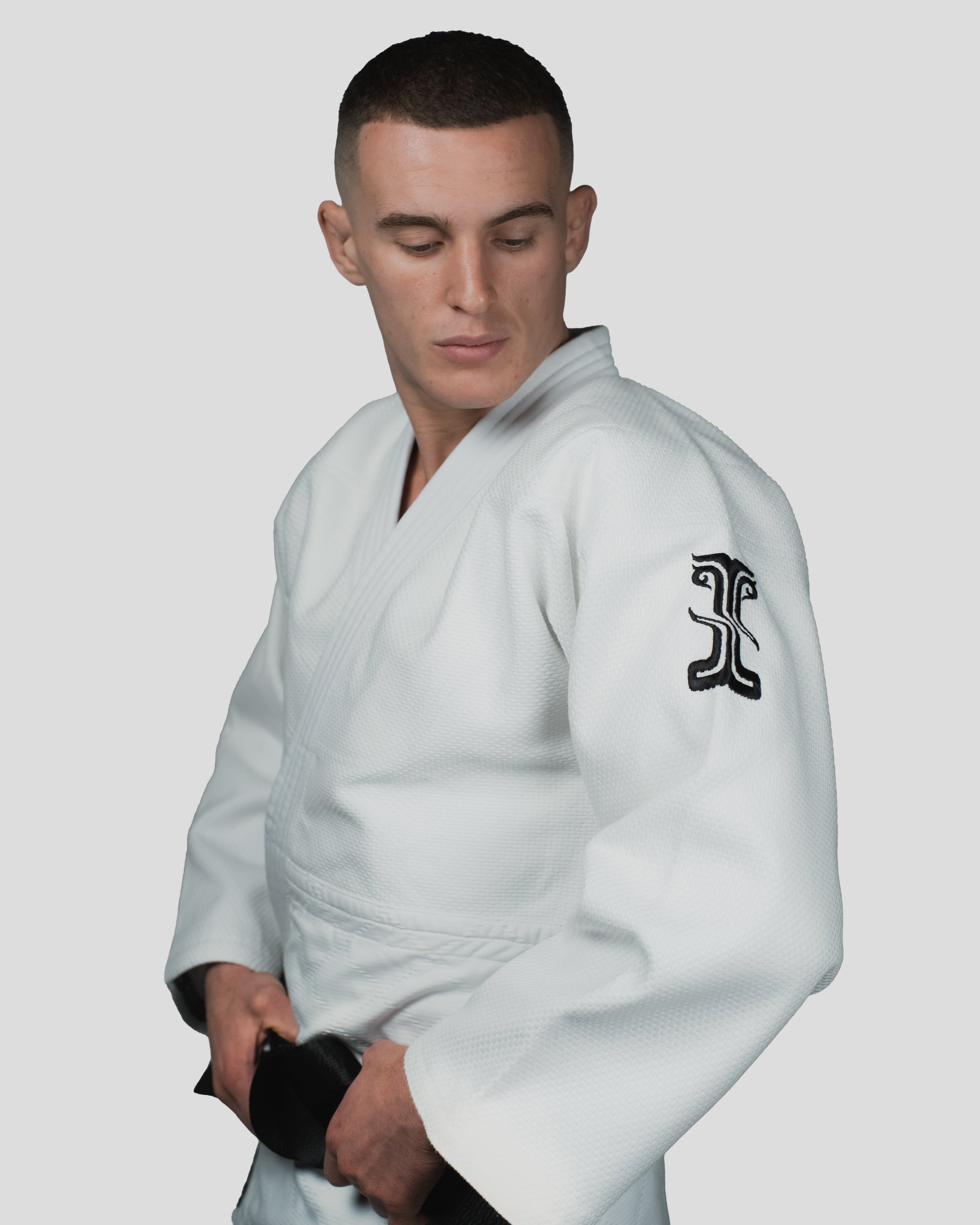 Side profile of the Stoa Gi Men's Judo uniform, showcasing the embroidered Kosmos logo on the shoulder