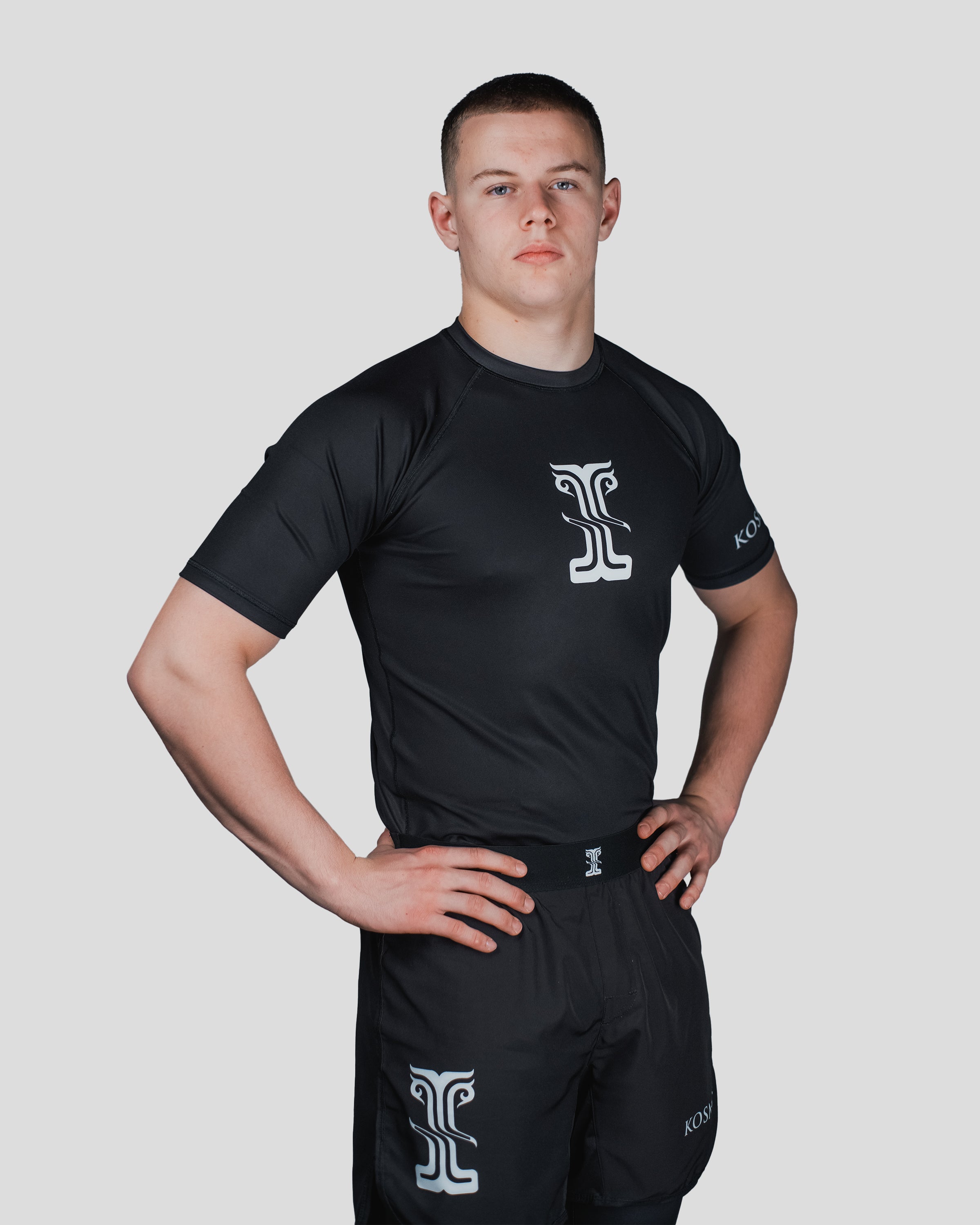 Side profile of the Column Guard rash guard, highlighting the streamlined fit and Kosmos branding on the sleeve