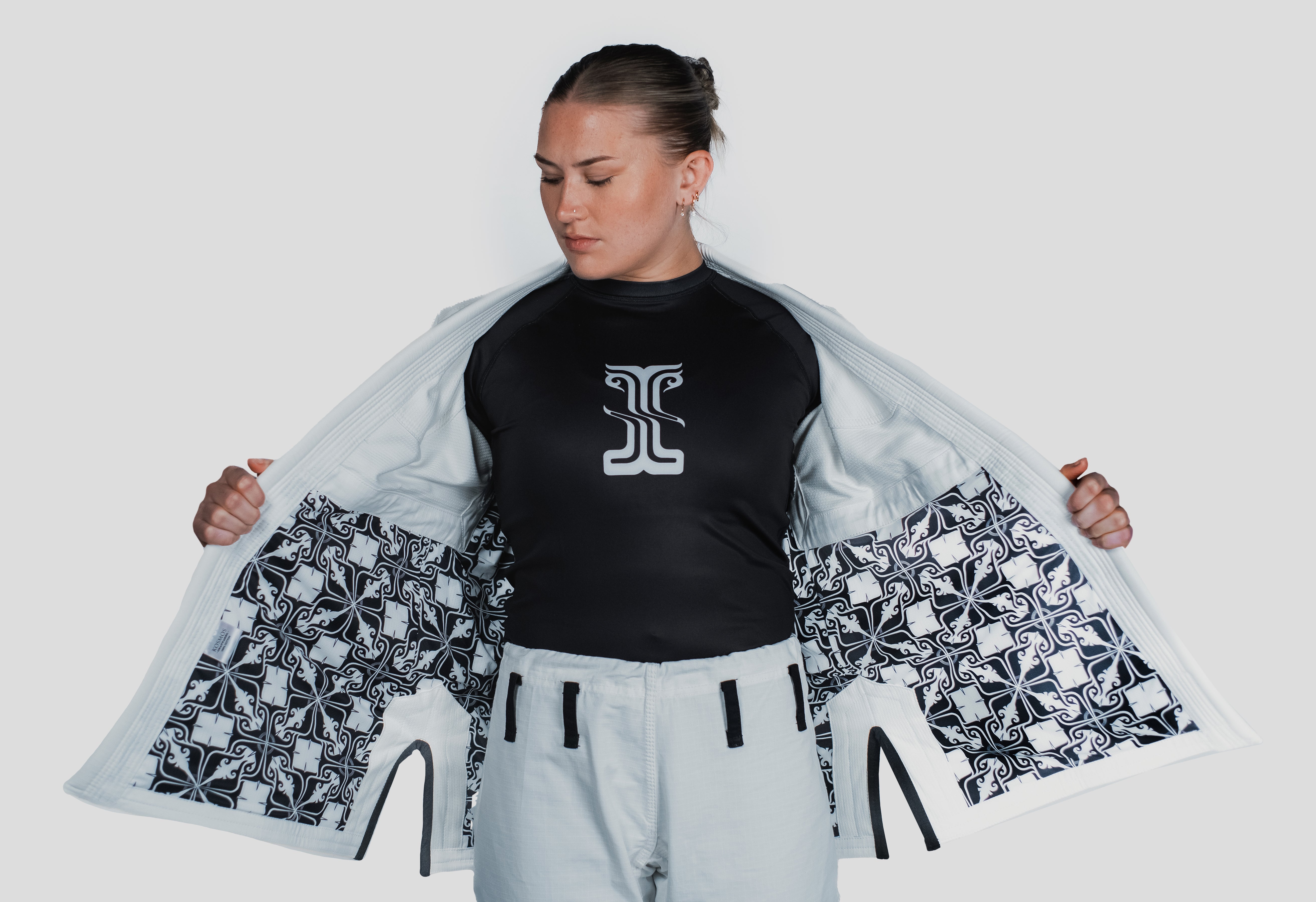 Inside view of the Guile Women's Jiu Jitsu Gi jacket, revealing the intricate black and white patterned lining for a unique aesthetic