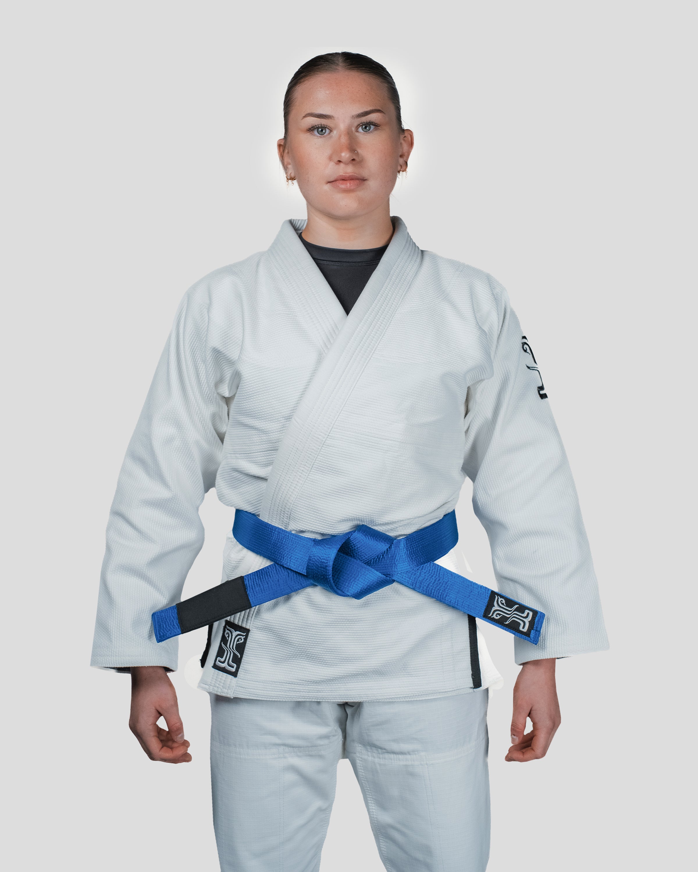 Straight-on stance of the Guile Women's Jiu Jitsu Gi, highlighting the reinforced stitching and Kosmos branding for high-performance training