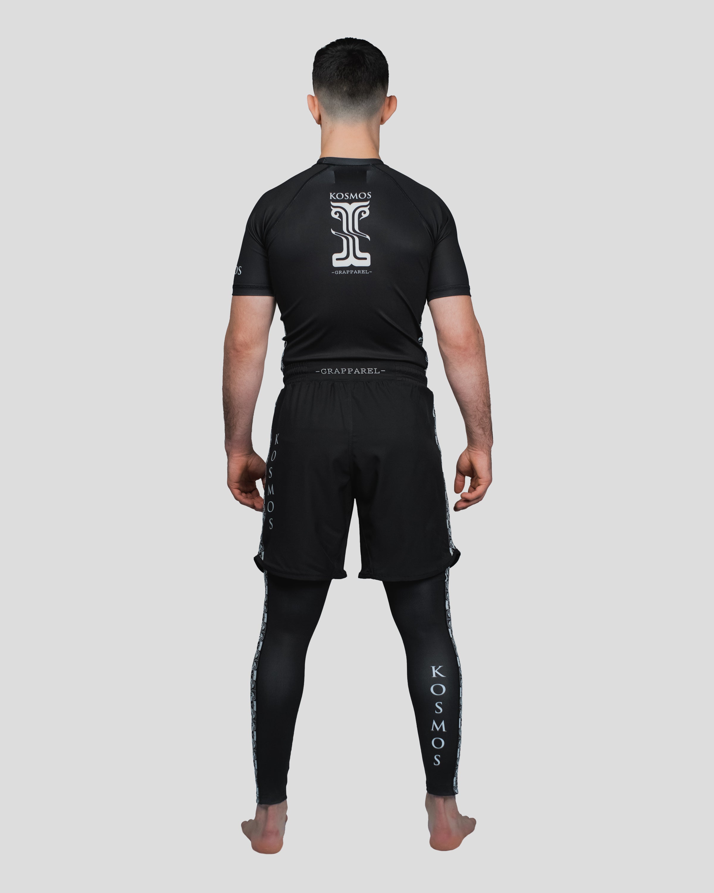 Back view of the Persist Guard Short Sleeve, featuring the Kosmos logo and ergonomic paneling for unrestricted movement