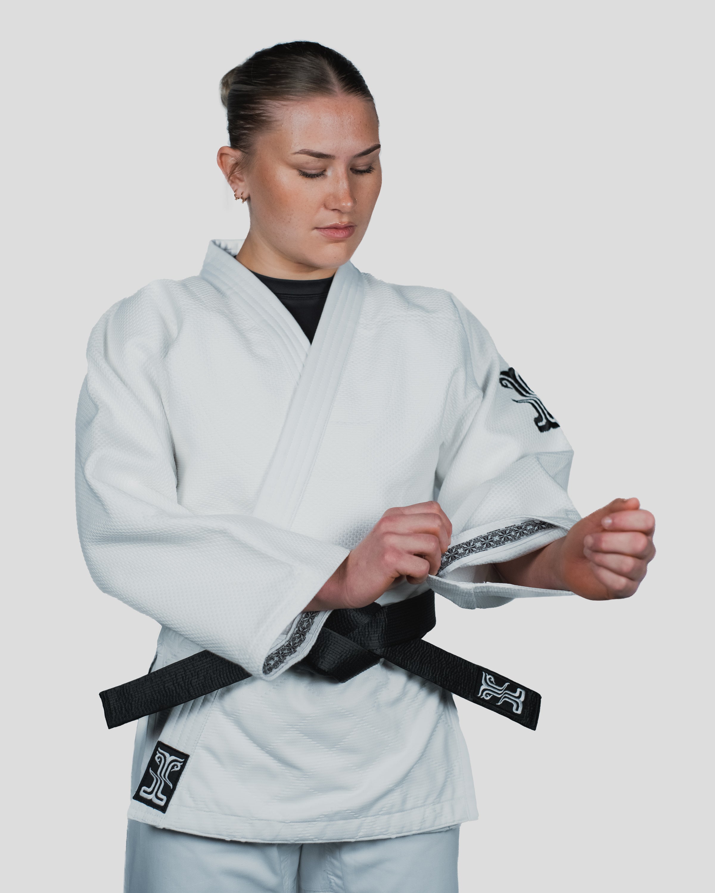 Close-up of the Stoa Gi Women's Judo sleeve, highlighting the detailed black and white trim and reinforced stitching